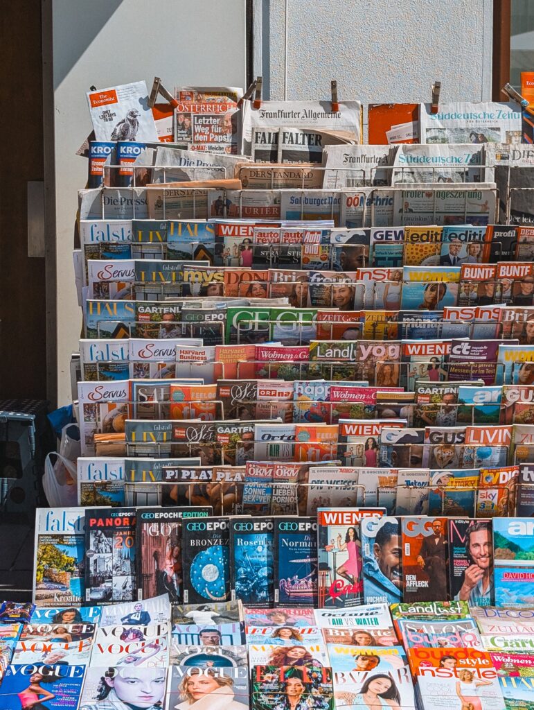 A vibrant display of various magazines and newspapers at a street stand, showcasing international publications.